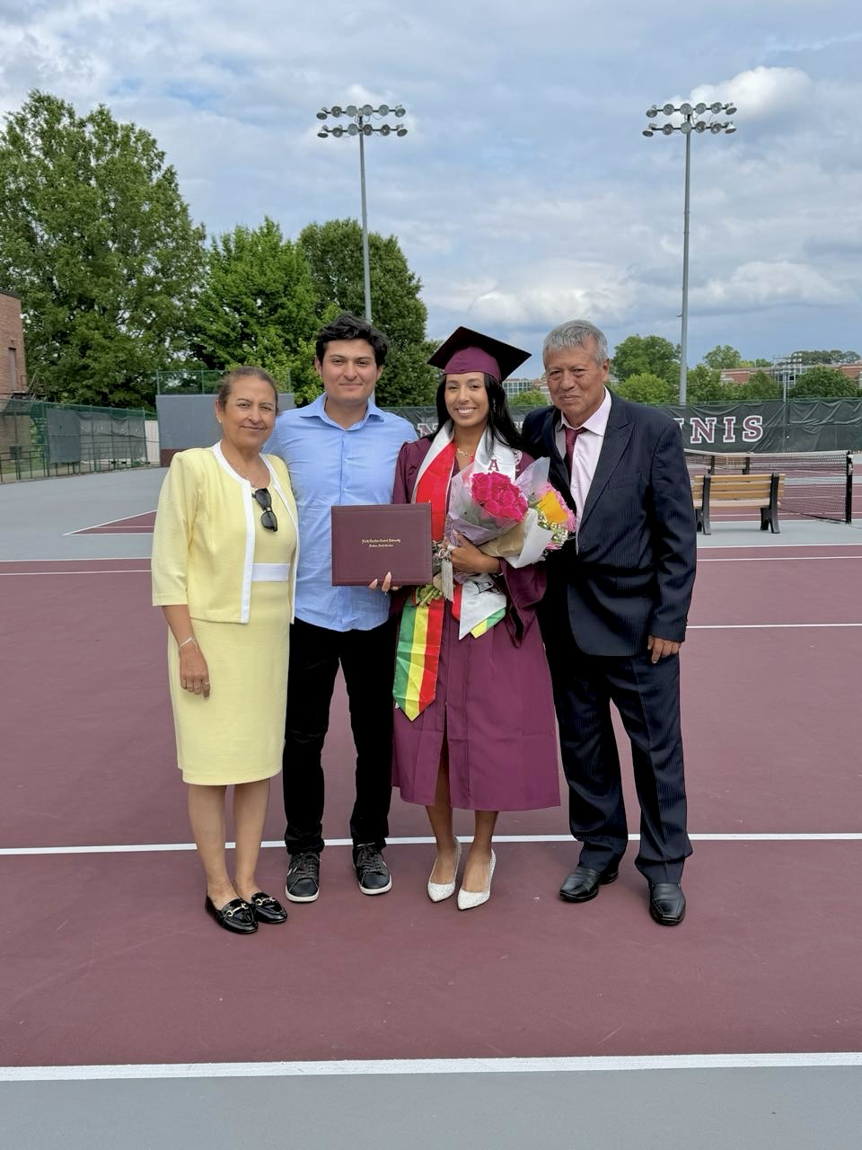 Valeria celebrating graduation with her family on the tennis court