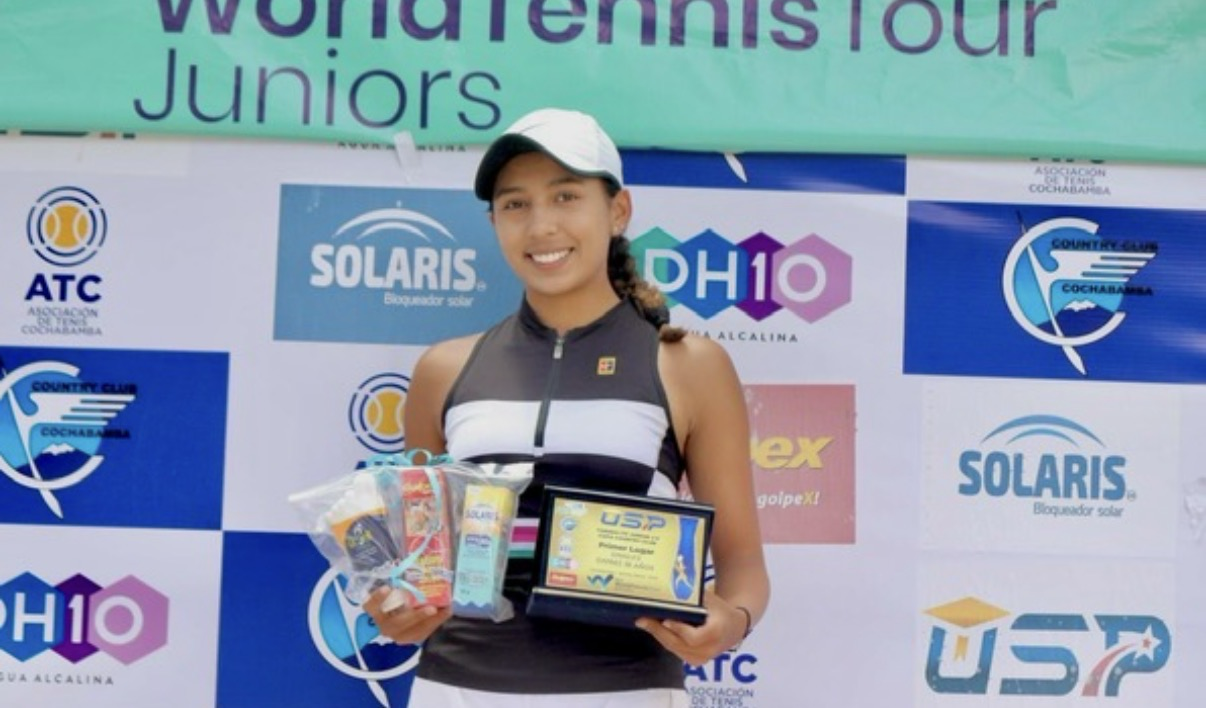 Valeria holding a trophy in a black striped tank