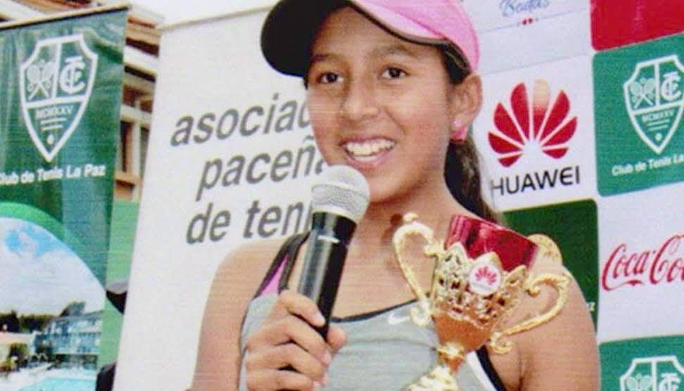 Young Valeria speaking into a microphone holding a trophy