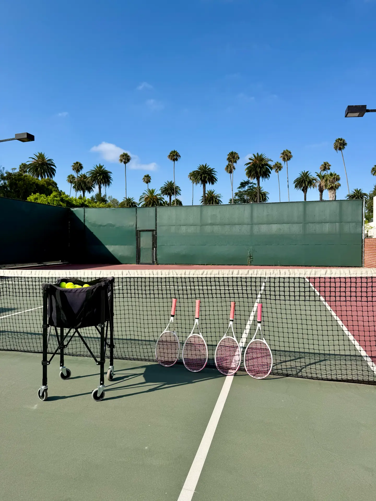 Tennis rackets and a ball basket on the City Tennis court